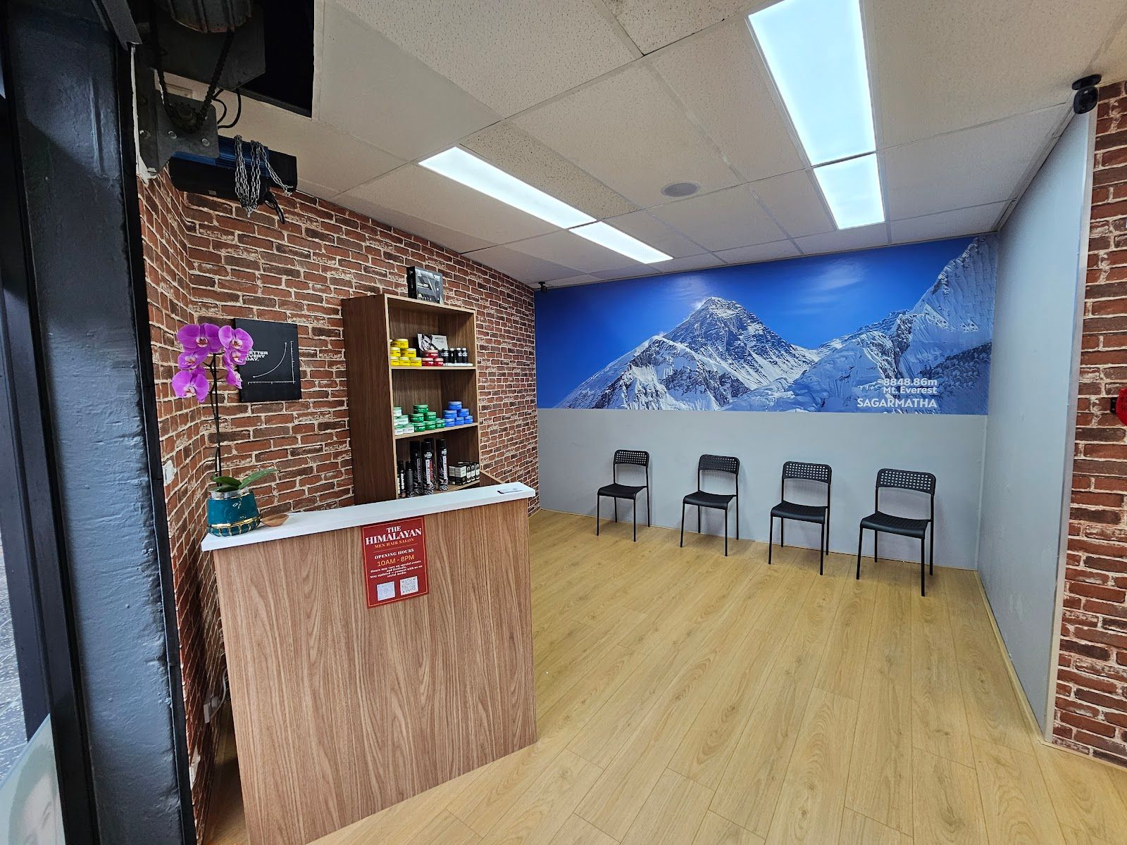 Waiting area with a mountain mural, chairs and a brick wall
