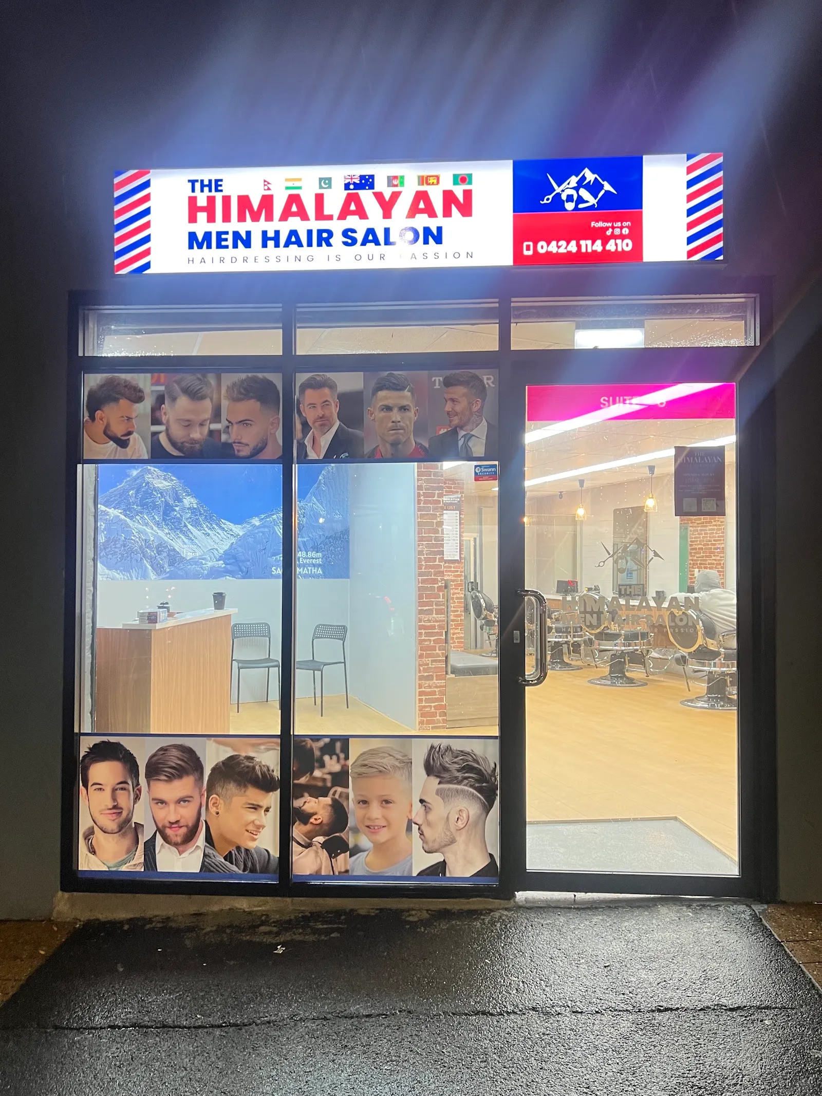 The salon front with its lit sign above the glass door